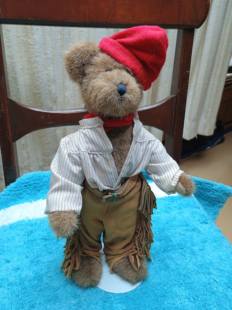 French Trapper Bear standing with a doll stand.